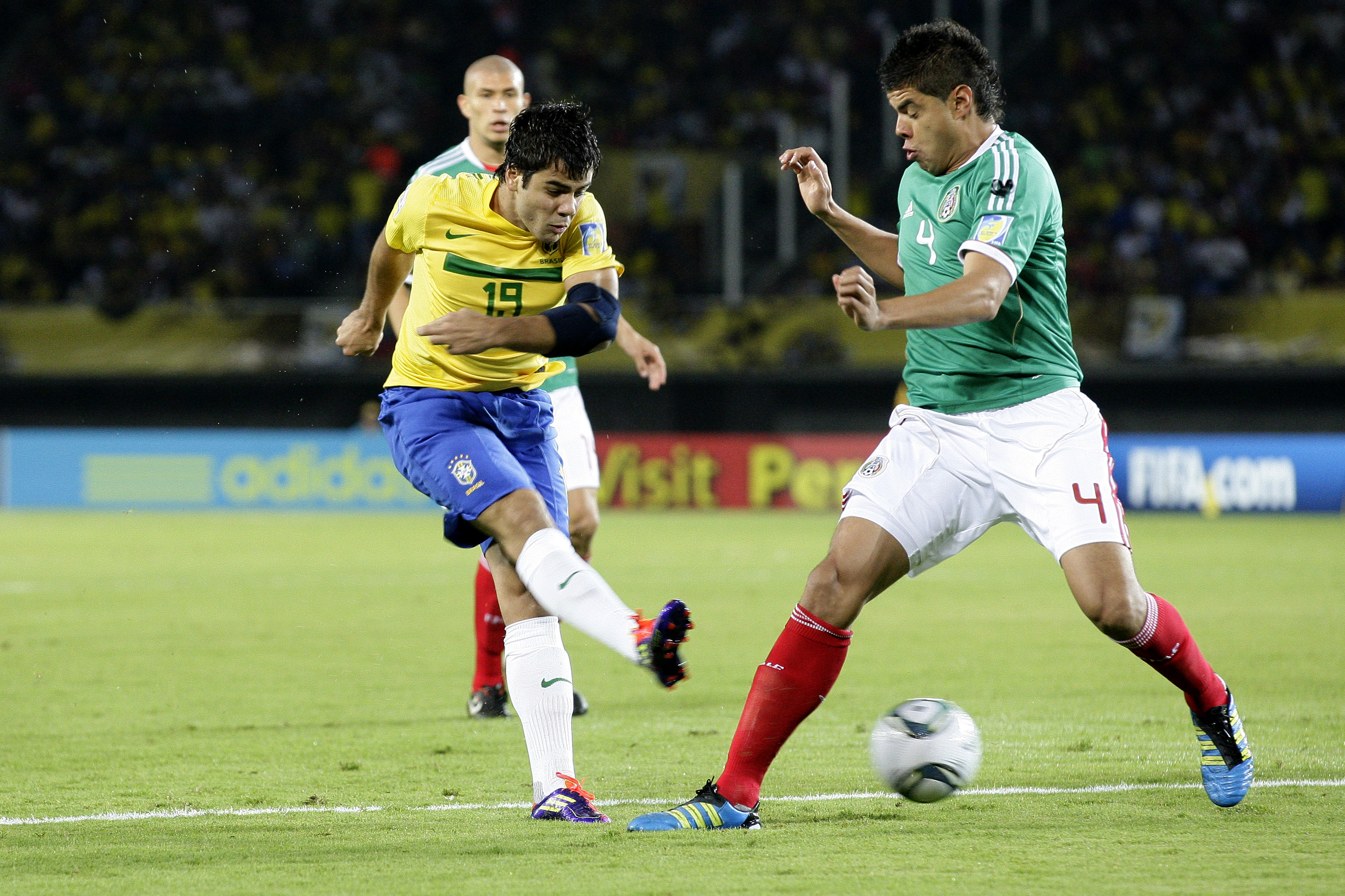 Henrique Almeda, scorer of both goals for Brazil, clashes with Néstor Araujo of Mexico in the semifinals of the FIFA U-20 World Cup in Pereira, Colombia, on August 17, 2011.